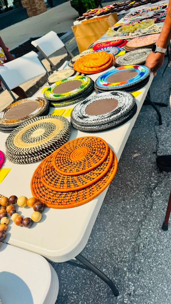Handwoven African wicker platters and baskets displayed at an outdoor vendor table