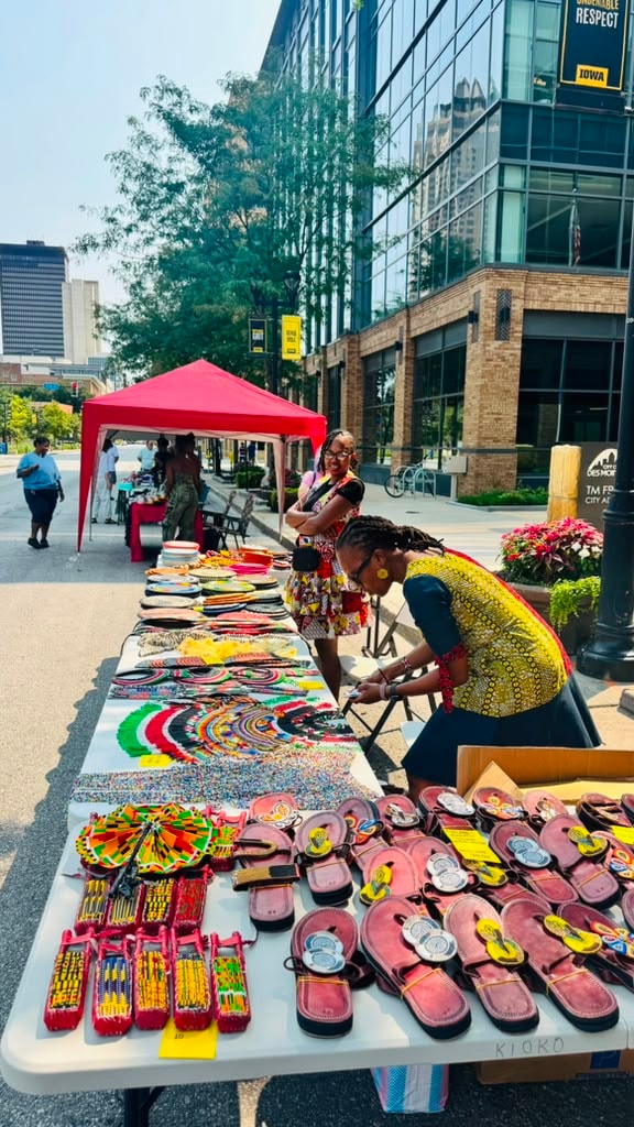 Vendor table with colorful African beaded jewelry, sandals and crafts in downtown Des Moines